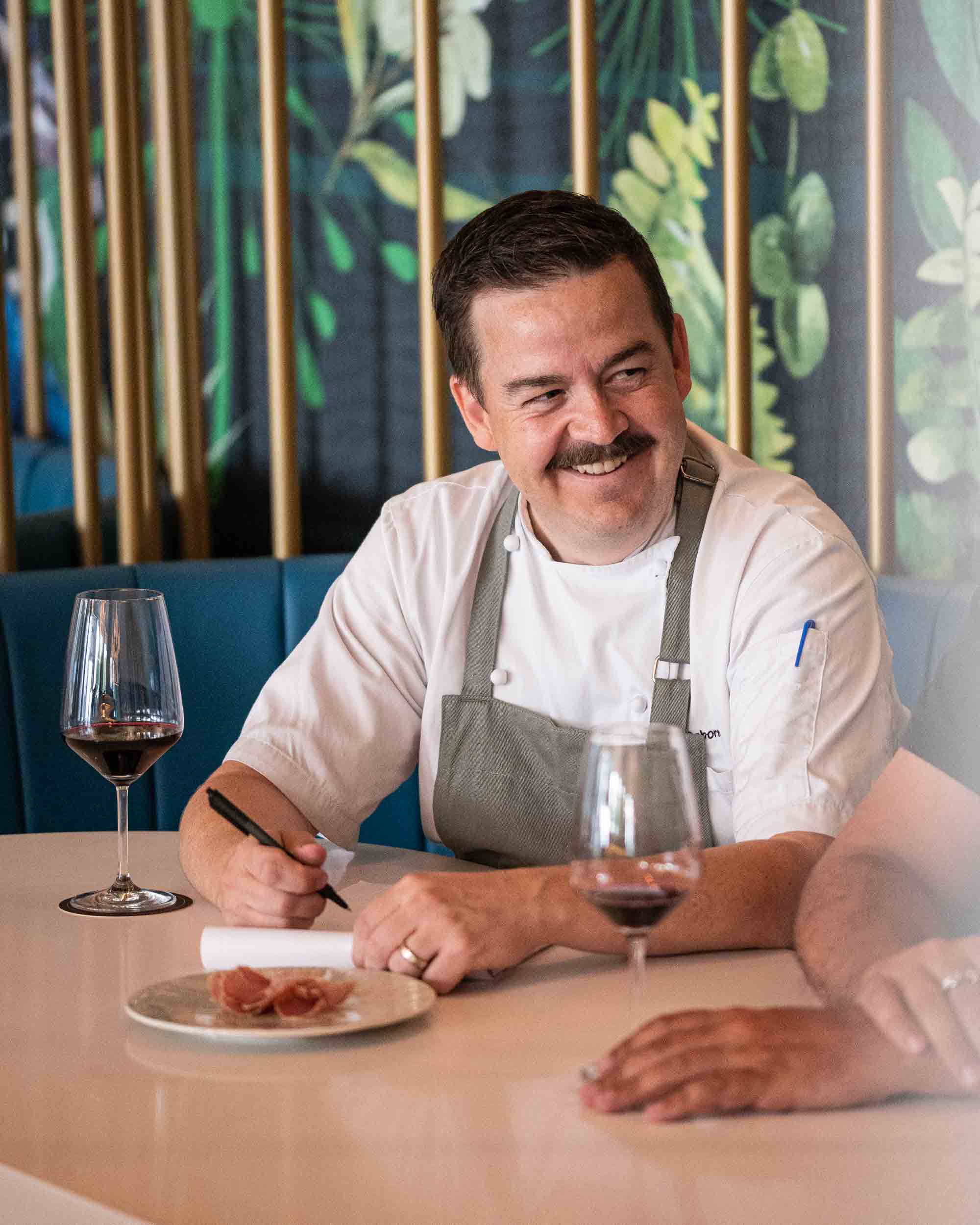 District executive chef Bill Osborne smiles and writes notes at Peacock Wine Bar Halifax