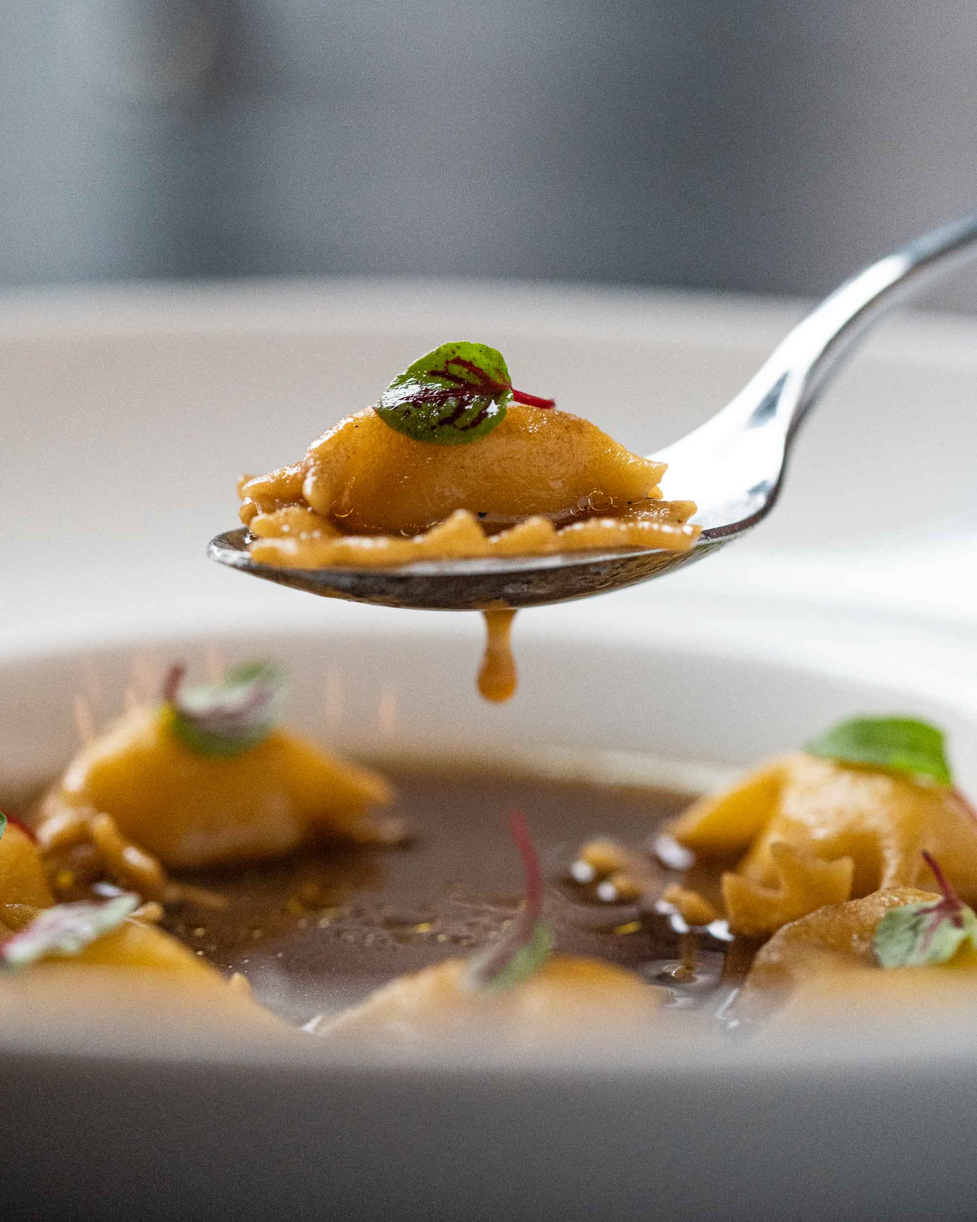 A close up of a spoon lifting a potato & parmesan agnolotti at Peacock Wine Bar Halifax